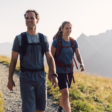 Familie wandert im Sommer auf einem Bergpfad in Gargellen, Kühe weiden auf der Almwiese. | © Gargellner Bergbahnen GmbH & Co KG, Daniel Zangerl