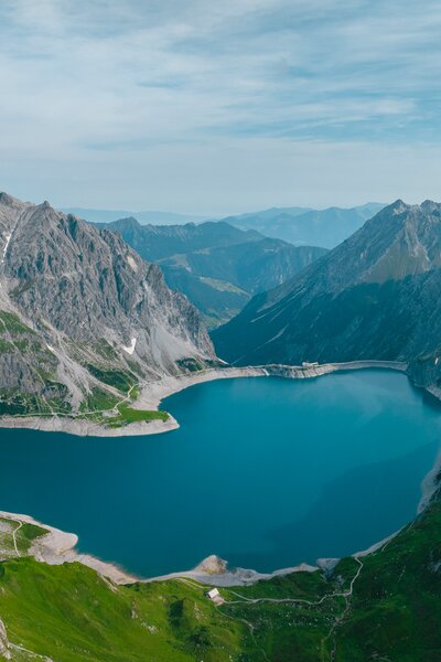 Heart-shaped lake surrounded by a beautiful mountain scenery photographed from above | © Golm Silvretta Lünersee Tourismus GmbH, Mathaeus Gartner